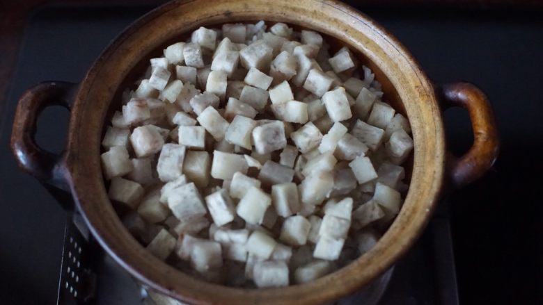 鳝鱼煲仔饭,放入煎炸好的芋头粒,盖上锅盖焖1分钟