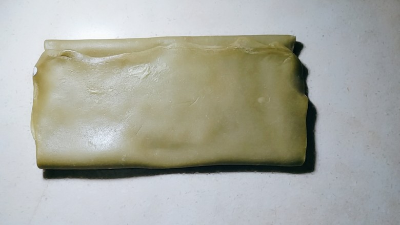 双色豆沙酥(玉米油版),擀成长25厘米,宽12厘米左右面片后,叠成3折。