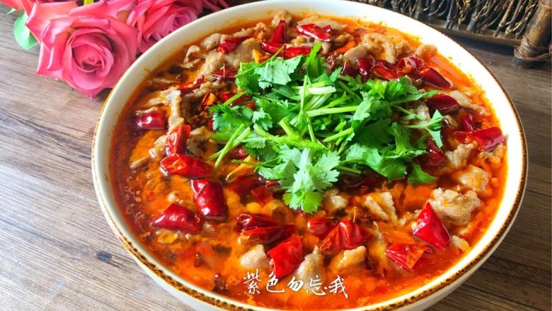 水煮牛肉,把辣椒和热油浇到牛肉上,撒上葱叶和香菜即可。