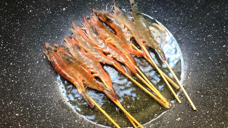 串串虾,锅里放入适量油,把虾串放入煎制
