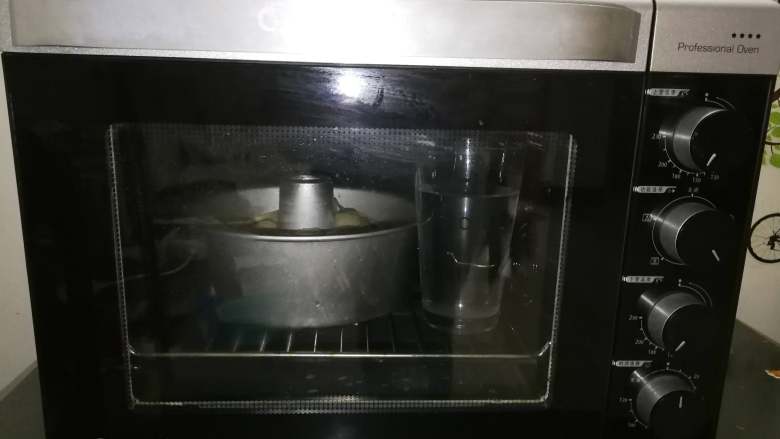 蔓越莓肉松酥粒面包,将切好的面块,放入8寸中空戚风模具,放入烤箱,烤箱不需要通电,直接在烤箱内放一杯热开水。将面团进行第二次发酵。
