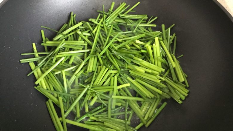 韭苔香干炒牛肉丸子片,待锅内油七分热时,下韭苔