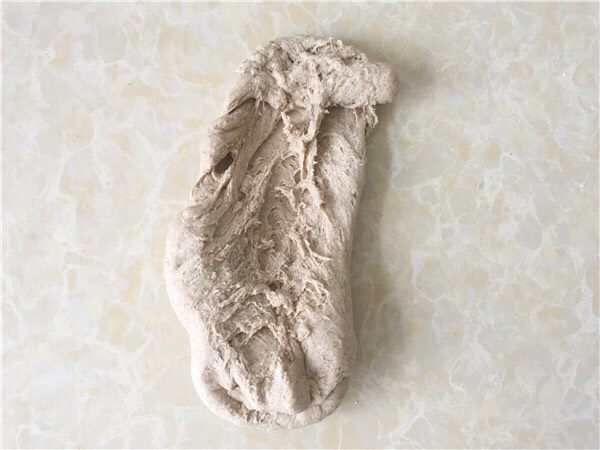黑麦奶酪包,倒在揉面垫上,用手掌一直向前推揉面团,将面团揉至表面光滑不粘手,面团起筋