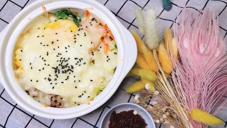 剩菜剩饭大作战:芝士石锅拌饭,撒上炒熟黑芝麻,加入拌饭酱拌匀。