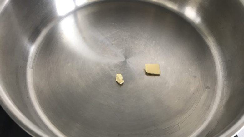 芒果盒子蛋糕,平底锅小火加热,用一小块黄油放在锅中抹均匀。