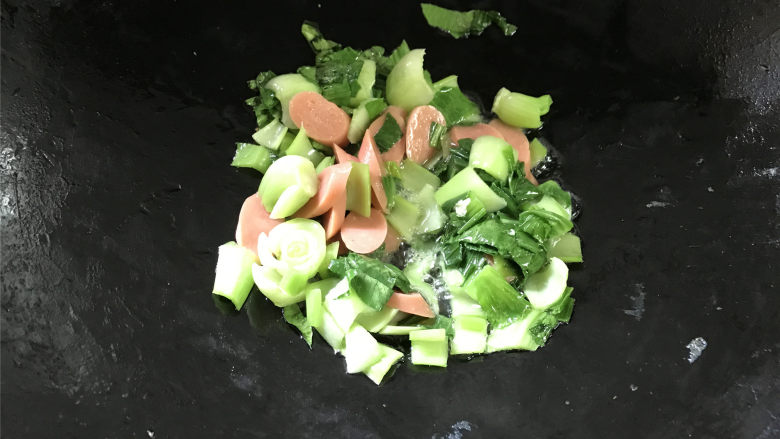 青菜鸡蛋炒面,炒匀后放入切成片的火腿肠一起翻炒。
