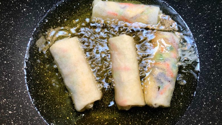 炸春卷,锅里放入500ml油,烧至7成热,放入春卷,接口的地方朝下,小火炸一下,待春卷定型再翻面