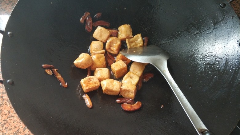 上班族快手菜~豆干炒香菇,倒入炸好的豆干,中火翻炒一下