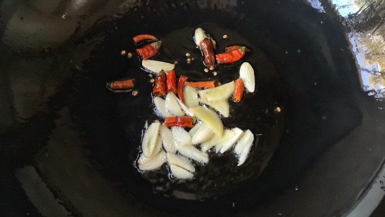宫保杏鲍菇,锅中适量油烧至7成热,下入姜蒜片,干辣椒段爆出香味。