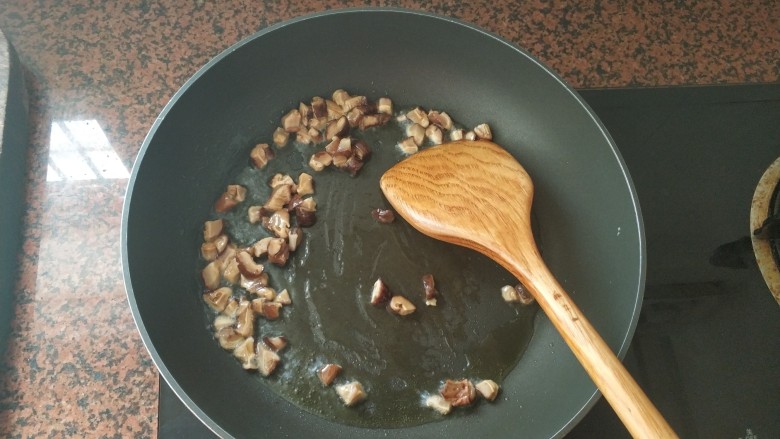 板栗香菇鸡肉焖饭,油热后,倒入香菇粒,中小火翻炒,爆香下