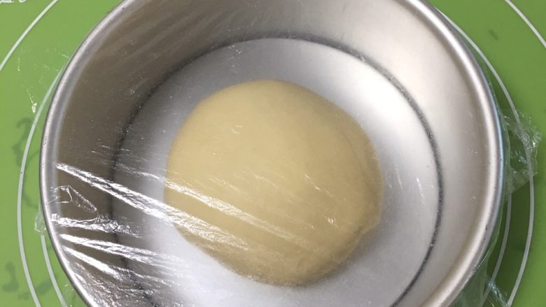 香葱肉松吐司面包,面团整理滚圆,盖上保鲜膜。
