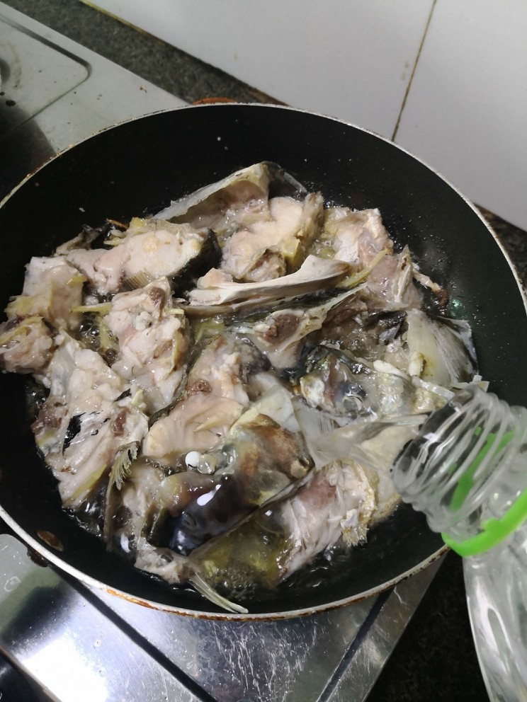 鱼头豆腐清汤,鱼头煎至两面干水金黄,倒入适当纯净水