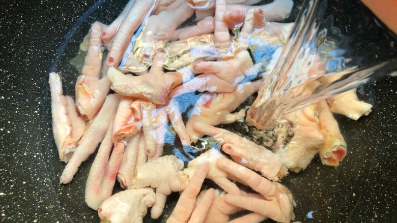 肉蟹煲,鸡爪放入锅里,放入适量水,大火把水煮开,把鸡爪焯出血末关火