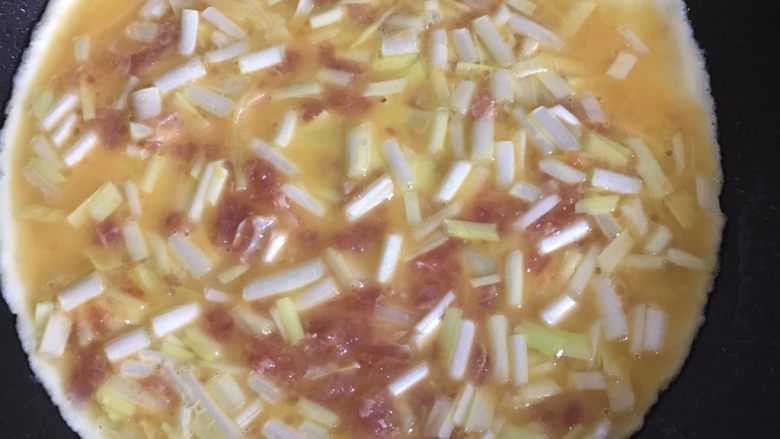 韭黄瘦肉煎蛋,热锅放入菜油,舀上蛋浆,慢火煎至两面金黄