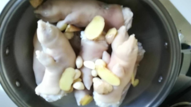 新文美食 秘制猪蹄,放入姜片。
