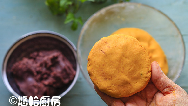 南瓜糯米饼,用手抓一块面团,捏成圆形,包入适量的豆沙馅,捏紧收口,再压扁成小饼状。