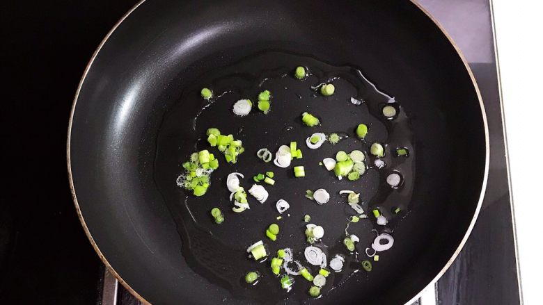 什锦火腿炒年糕,油烧热后加入加入葱花,煸炒出香味