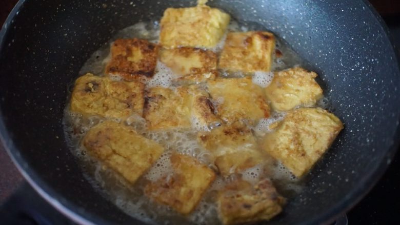 锅塌豆腐,将锅里的油全部倒出,放入煎好的豆腐,加入适量开水