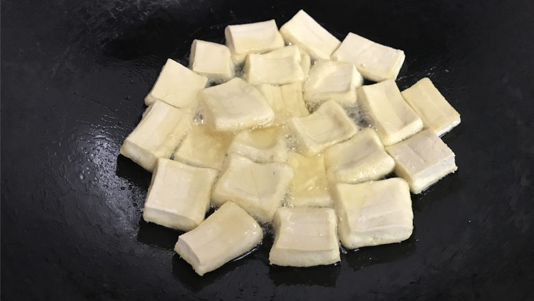 叉烧豆腐,5成热时放入切好的豆腐转,用中火炸制。