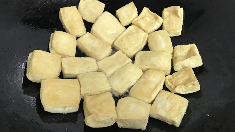 叉烧豆腐,一面炸好后翻面再炸另一面,直至两面都炸至表皮稍硬、色泽金黄后沥油捞出。
