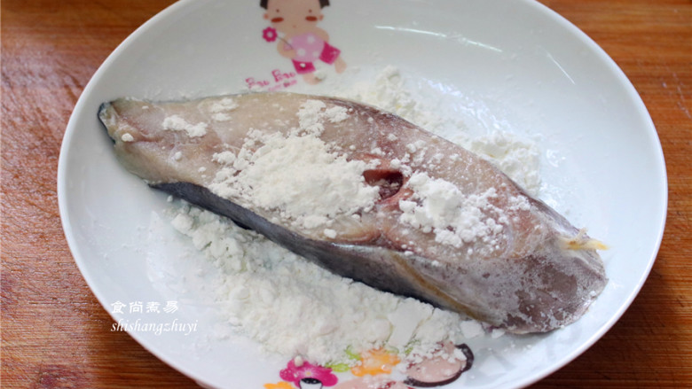 香煎马鲛鱼,干淀粉用碟子盛起,提起马鲛鱼在淀粉上两面粘一下