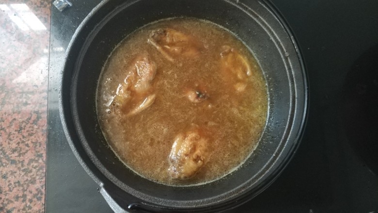 黄梅酱橙汁鸡翅,大火煮开,由于平底锅有点大,换了铁铸锅