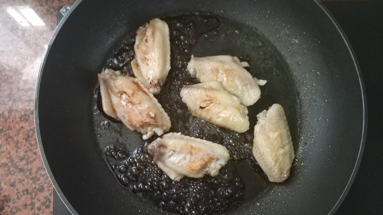 黄梅酱橙汁鸡翅,油热后放入鸡中翅,煎至两面金黄