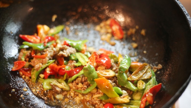 美食丨湘菜经典 奇丑无比却美味无穷的猪血丸子,起锅热油,放入大蒜头、一半姜片爆香,加入辣椒。加入少许盐,调个底味。