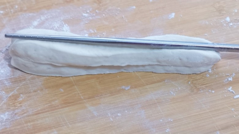 早餐+蓬松大油条,取两条面捏在一起,用一根筷子放在条状面团的中间,压出印记,压悄悄深一点!压好一面再反过来压痕迹!(两面都要用筷子压出印记)