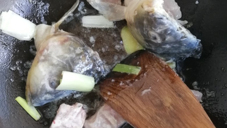 酸菜鱼(无辣),起锅烧油,葱姜爆香,加入鱼头鱼尾鱼骨,加入酸菜,翻炒约一分钟