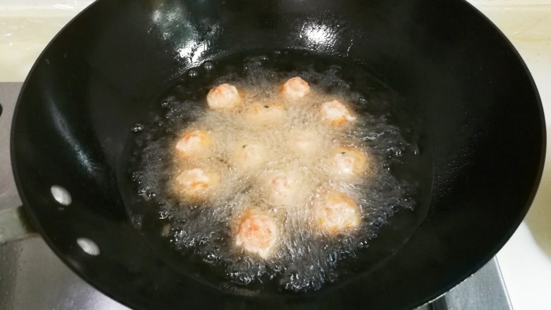 胡萝卜末肉圆,锅中放入适量食用油烧热,用勺子挖肉糊放入锅中中火炸至表面定型成浅黄色