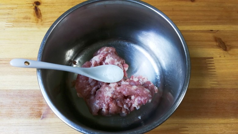 腌绿辣椒胡萝卜水饺,盘中放入肉糜,放入一小勺盐