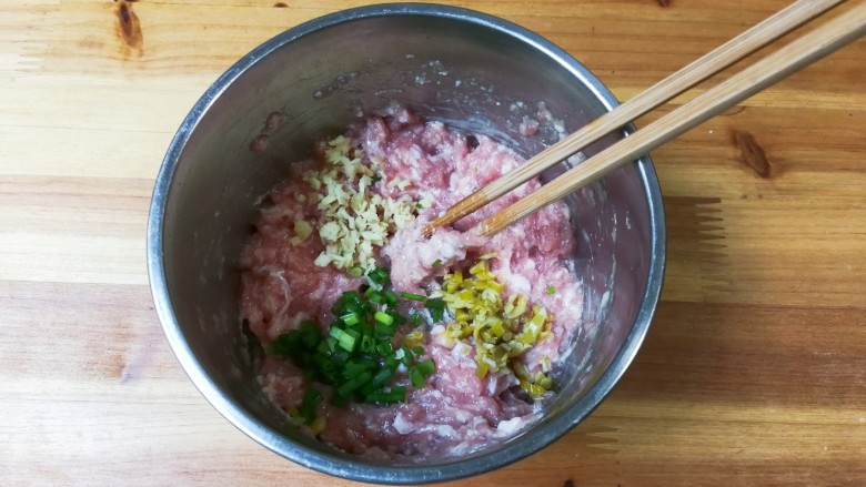 腌绿辣椒胡萝卜水饺,放入一小勺糖,少许清水顺时针搅拌至有粘性