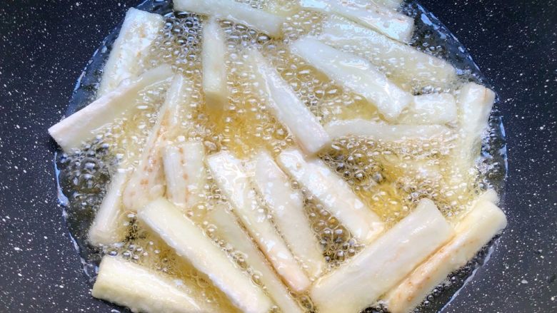 咸鱼茄子煲,锅里放入500ml油,烧至9成热,把茄条放入炸制