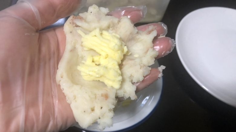 超软金枪鱼奶酪土豆饼,准备好奶酪。将土豆泥平均分成八份,每一份摊开包入一些奶酪。