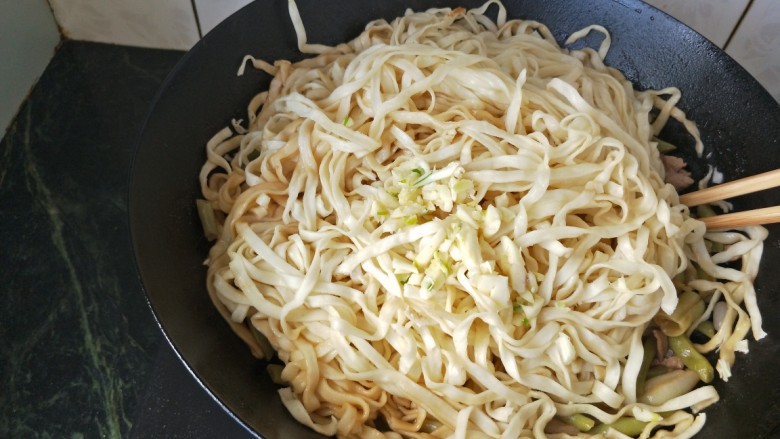 豆角肉丝焖面,放入蒜末将面翻面于豆角拌匀即可出锅