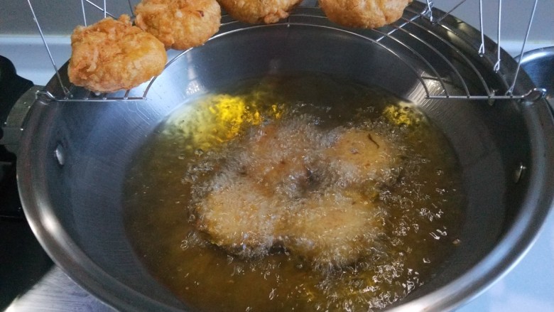 新文美食 玫瑰豆沙馅炸糕,炸制好的黄米糕先控油在放入盘中。