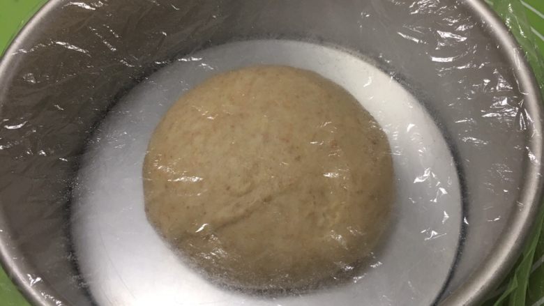 粗粮健康包,将面团整理滚圆,盖上保鲜膜。