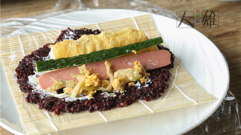 回忆杀,自制咸蛋黄肉松紫米饭团子,下面我们开始来做饭团啦:先铺上一层米饭,用勺子压平压均匀,爱吃沙拉酱的可以放一些(怕月半的少女们跳过),再把食材按照个头大小的顺序依次放上:油条、火腿条、黄瓜条、蛋黄碎、榨菜、肉松,但注意不要贪心放太多否则不容易卷