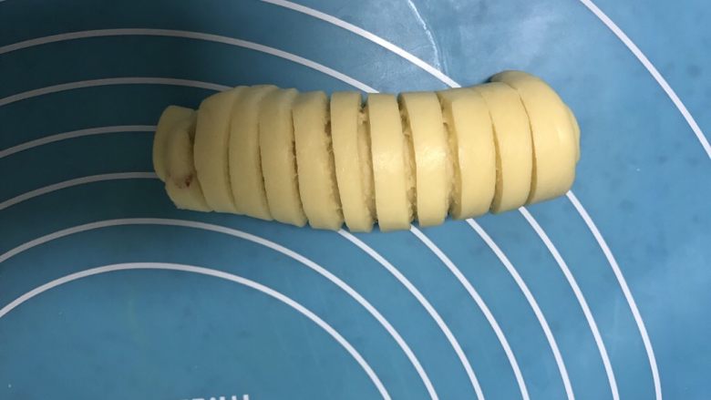 懒人版毛毛虫蓝莓面包,再长舌状面皮的另一端从下往上卷起来,卷到头就可以了。