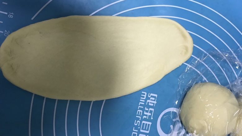 懒人版毛毛虫蓝莓面包,取一块松弛好的面团,用擀面杖擀成长舌状。