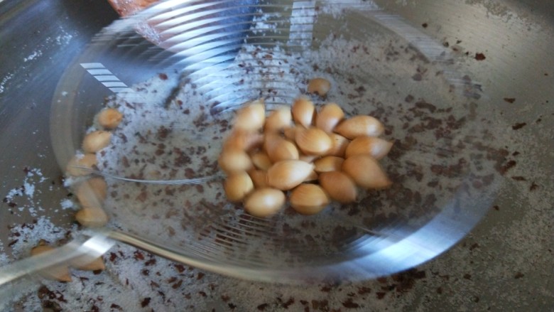 盐炒银杏果,看到变黄色即可关火,用漏勺过滤出食盐。