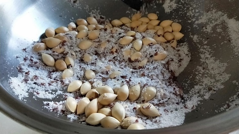 盐炒银杏果,皇后锅倒入一袋食用盐300克,倒入银杏果小火翻炒。