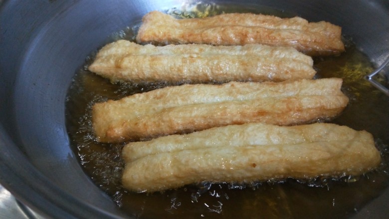 新文美食 自制好吃的无矾油条,不停翻动,炸制金黄捞出来。