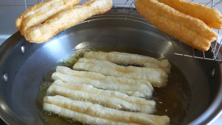 新文美食 自制好吃的无矾油条,放入铁架控油。