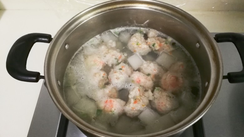 冬瓜胡萝卜肉圆汤,用手挤肉圆放入锅中,盖上盖子烧至肉圆全部漂浮起来