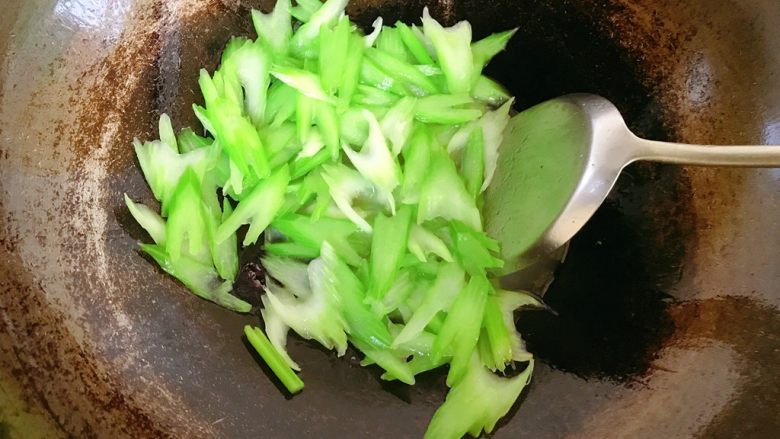 西芹百合炒肉片,锅中热油,把西芹炒至断生暂出锅。