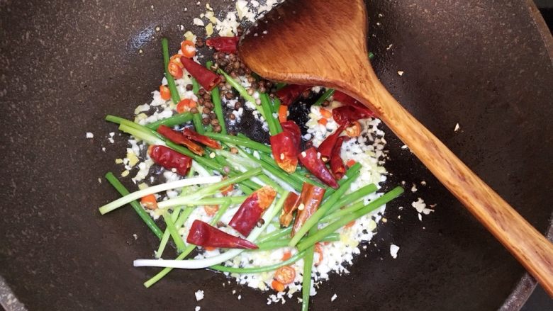 水煮肉片,接着放葱段，干辣椒和花椒，炒出香味