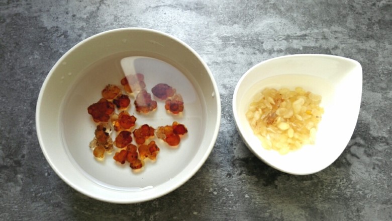 桃胶皂角米银耳羹,<a style='color:red;display:inline-block;' href='/shicai/ 2530'>桃胶</a>和<a style='color:red;display:inline-block;' href='/shicai/ 6363'>皂角米</a>适当清洗后分别放入大碗中,用纯净水浸泡2小时。<a style='color:red;display:inline-block;' href='/shicai/ 2530'>桃胶</a>变软后,需要仔细清除<a style='color:red;display:inline-block;' href='/shicai/ 2530'>桃胶</a>里的杂质,换上干净的纯净水继续泡发过夜。品质较好的<a style='color:red;display:inline-block;' href='/shicai/ 6363'>皂角米</a>不会有太多杂质,略微清洗后,换上干净的纯净水继续泡发过夜。夏天需要放入冰箱泡发,以免变质。