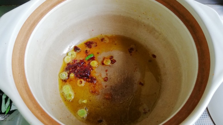 鱼香茄龙煲,砂锅入油预热,放入郫县豆瓣酱和一半葱花煸香